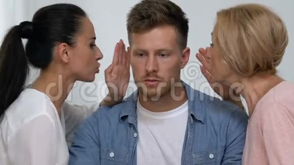 母亲和妻子对男人耳语秘密互相抱怨视频的预览图