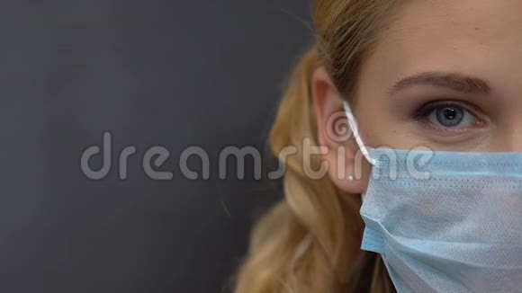 女性美容师戴着保护面具看镜头半脸特写视频的预览图