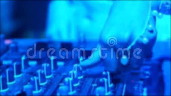 在夜总会迪斯科晚会上Dj混合机控制台的Blur特写DJ双手触摸按钮和滑块播放电子音乐视频的预览图