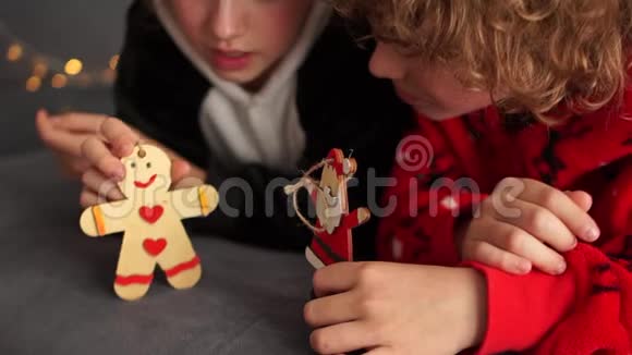 穿睡衣的孩子玩圣诞礼物手里拿着木娃娃的男孩和女孩圣诞快乐视频的预览图