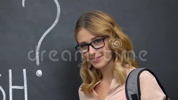 戴眼镜的学生拿着书你在黑板上说英语吗教育视频的预览图