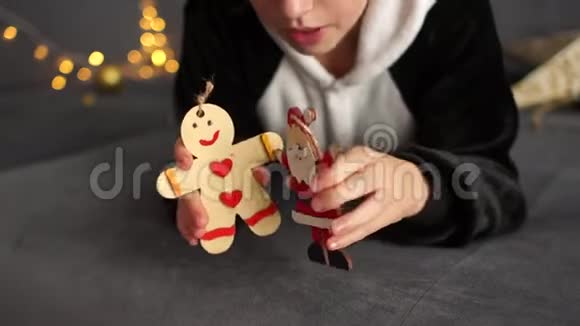 穿着羊毛睡衣的卷曲女学生玩木制的圣诞人物准备圣诞晚会新年视频的预览图