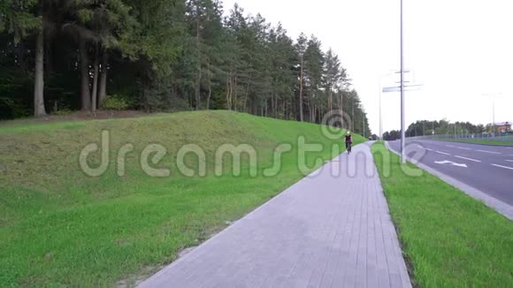 女骑自行车女骑自行车在街上超速从山上没有头盔危险的骑鼓舞人心视频的预览图