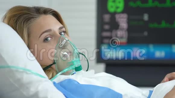 忧郁的患病妇女带着氧气面罩哭着看着相机疾病疼痛健康视频的预览图