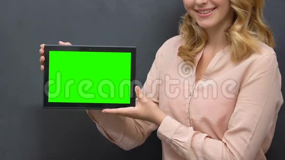 女士向相机移动服务应用展示绿色屏幕平板电脑视频的预览图