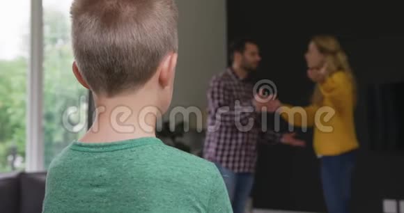 男孩站着而父母在家里的背景下争吵视频的预览图