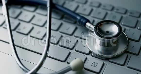 笔记本电脑键盘上的医用听诊器电脑维修服务或电子健康概念视频的预览图