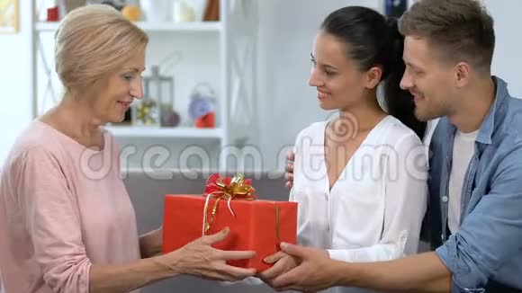 可爱的一对夫妇向婆婆赠送礼物盒庆祝父母的生日视频的预览图