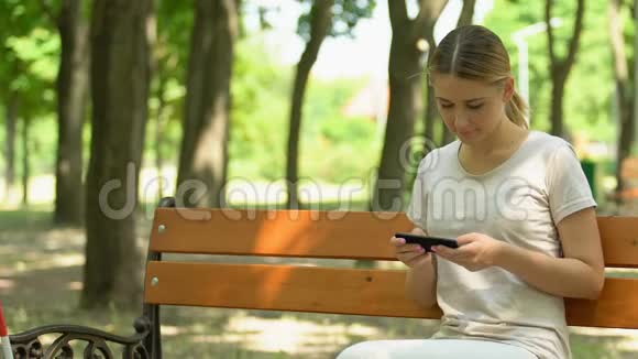 年轻女孩帮助成熟的盲人坐在公园的长凳上善良视频的预览图