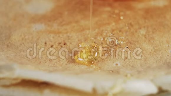 一缕金色的蜂蜜流在一条细细的小溪里放在刚烤好的煎饼上视频的预览图
