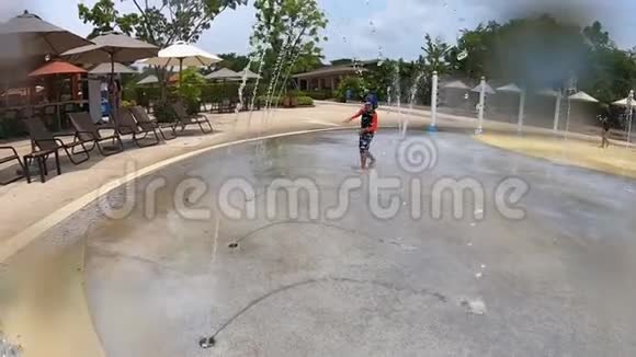 男孩在水上乐园的水上游乐场里跑步视频的预览图