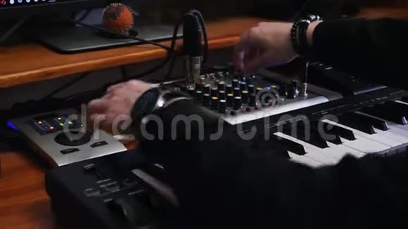 声音工程师工作站与声板MIDI钢琴和声音工程师混合板双手转动旋钮按下按钮视频的预览图
