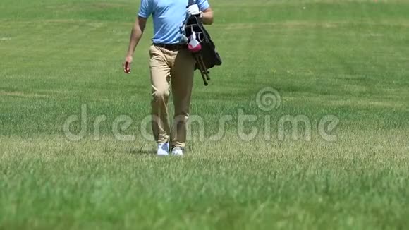 自信的高尔夫球手拿着高尔夫球袋在球道上走着完成了他的比赛视频的预览图