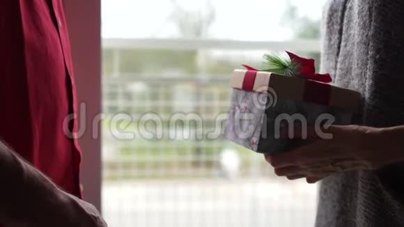 亲密肖像成熟男女互祝圣诞快乐一个男人送一个女人礼物两个人轻轻亲吻视频的预览图