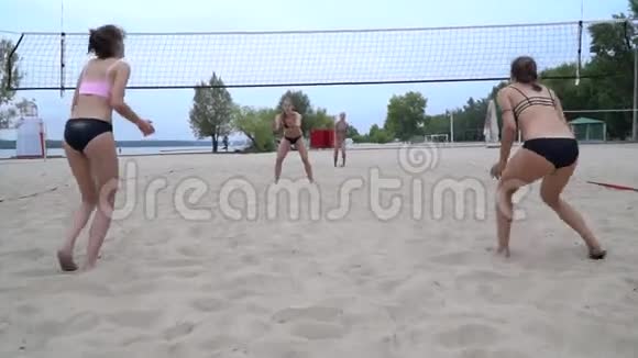 在沙滩上打排球四个穿比基尼的女人正在比赛视频的预览图