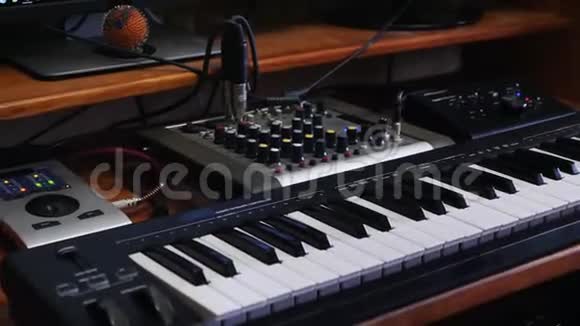 家庭音乐录音工作室工作区与混音板和键盘声音工程师转动混音器上的旋钮穆西视频的预览图