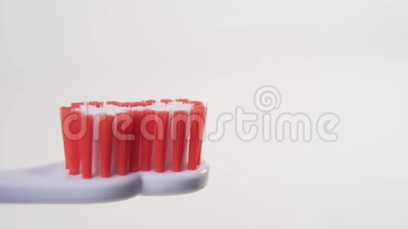 一只手把一支蓝色牙膏从管子里挤到一支白色塑料牙刷上上面有一个鬃毛视频的预览图