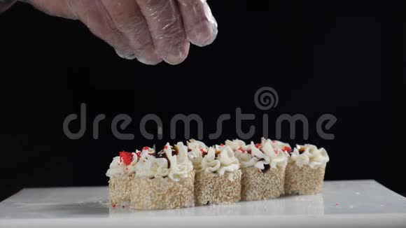 厨师用芝麻浇卷芝麻落在寿司卷上慢动作镜头寿司板块收拢高清高清视频的预览图