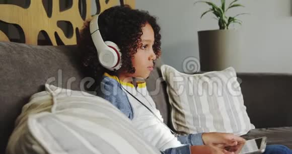在4k医院大厅带耳机的白人男孩在数字平板电脑上玩游戏视频的预览图