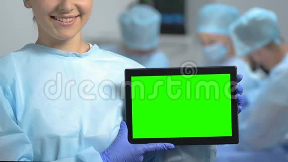 微笑医学生拿着绿色屏幕的平板电脑在医院实习视频的预览图