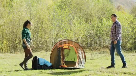 美丽的妻子帮助丈夫搭起了露营帐篷视频的预览图