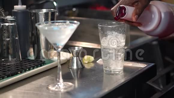 酒吧男将红糖浆倒入装有冰块的玻璃杯中加入世界大都会鸡尾酒视频的预览图