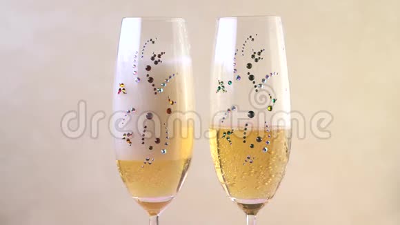 两个带有莱茵石的玻璃杯里装满了香槟泡沫视频的预览图