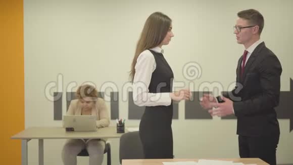 愤怒的年轻老板在前台对他的秘书大喊大叫胖女同事坐在后台冲突视频的预览图