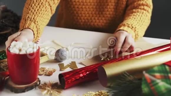 年轻女孩在桌上喝热巧克力和圣诞礼物视频的预览图