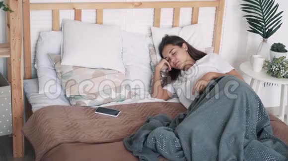 女孩睡在床上从电话中醒来说话睡着慢动作视频的预览图