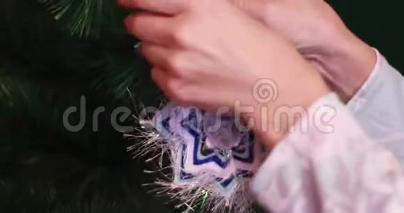女手把新年玩具挂在圣诞树上圣诞节和圣诞老人视频的预览图