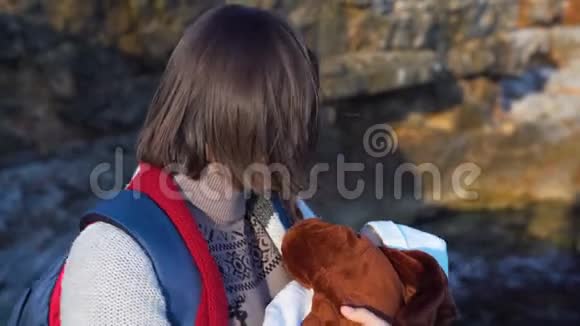 一位年轻漂亮的妈妈背着背包手里抱着一个熟睡的小男孩视频的预览图