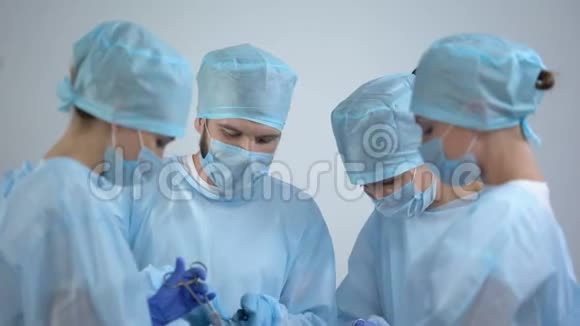 在手术室工作的外科医生团队护士检查监视器上的心电图率视频的预览图