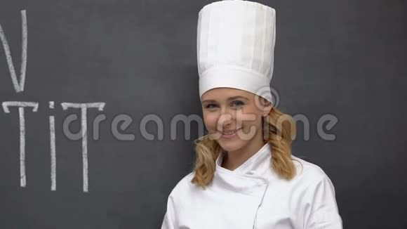 年轻的厨师微笑着在法语上展示刀叉一个令人垂涎的短语视频的预览图