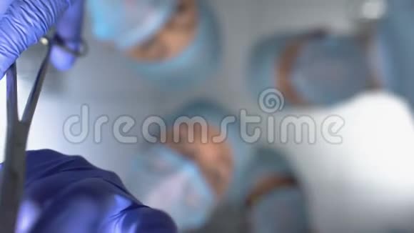 外科医生用医疗器械切割肿瘤以治愈病人底部视图视频的预览图