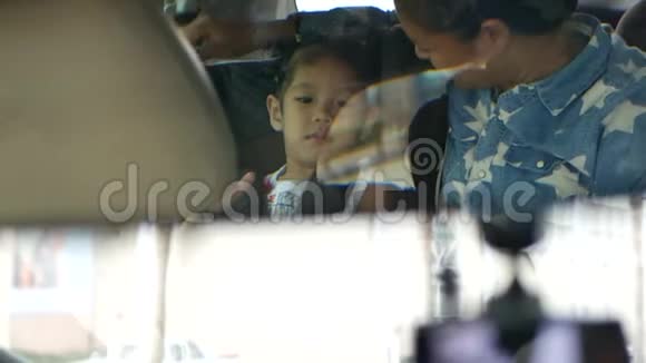 在一辆汽车罕见的镜子里小亚洲女婴正在和母亲玩耍和消磨时间视频的预览图