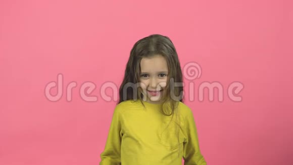 带着微笑的困惑孩子在粉红色的背景上拍手视频的预览图