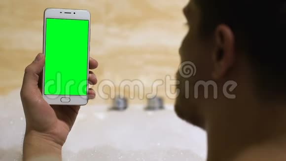 男人在浴缸里拿着预先键好的智能手机商业申请模板视频的预览图