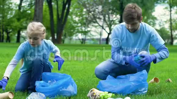 儿童和父亲生态志愿者在公园收集垃圾社会生态活动视频的预览图
