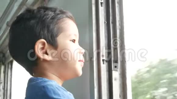 小亚洲女孩坐火车在火车窗口观看风景视频的预览图