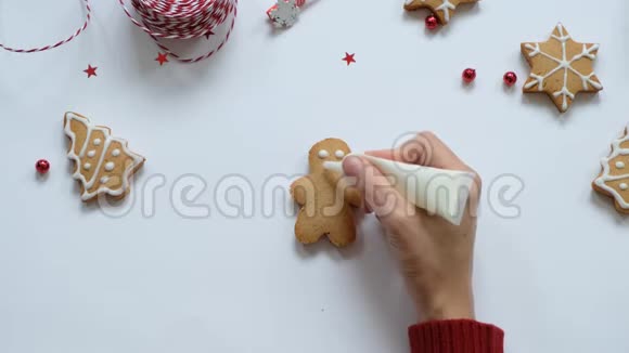 为圣诞节做姜饼饼干女人的手画饼干上有白色的釉顶部视图视频的预览图