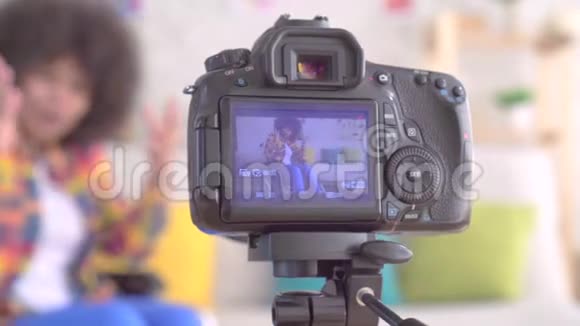 非洲女性博客作者在轮椅上残疾发型是非洲式的通过摄像机屏幕观看视频的预览图