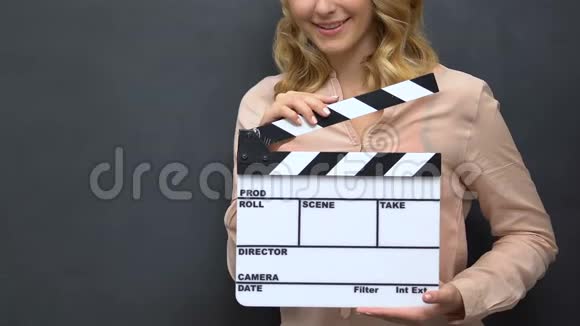 一位年轻女士在黑板背景电影拍摄中用孤立的挡板拍手视频的预览图