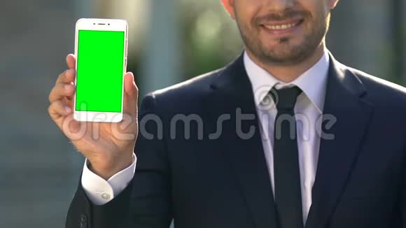 快乐商人手握智能手机绿屏在线应用现代科技视频的预览图