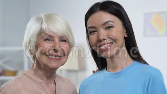 快乐的年轻和年长的女士看着镜头微笑着一代又一代的家庭成员视频的预览图