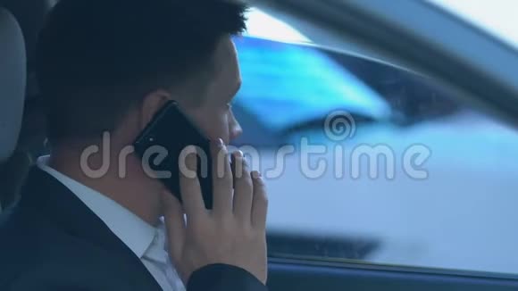 男性调查员坐在车上打电话监视罪犯独家新闻视频的预览图