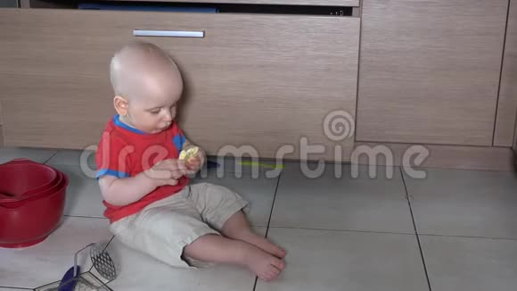 饥肠辘辘的男孩在厨房地板上乱坐着吃东西视频的预览图