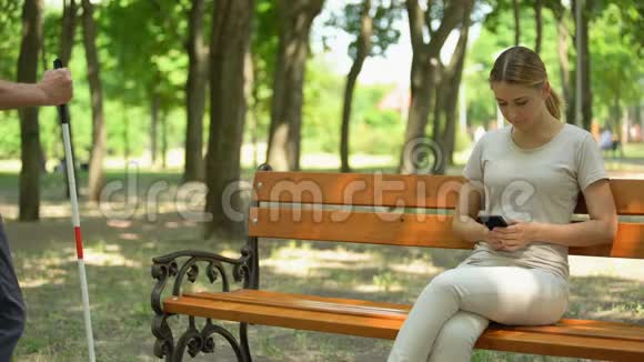 盲人老人笨拙地坐在长凳上靠近不礼貌的不满女孩视频的预览图