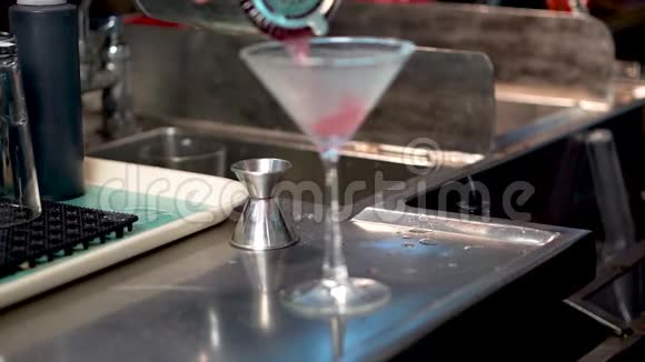 酒保将鸡尾酒倒入柜台上的摇床上的玻璃杯中这是大都会鸡尾酒的特写视频的预览图