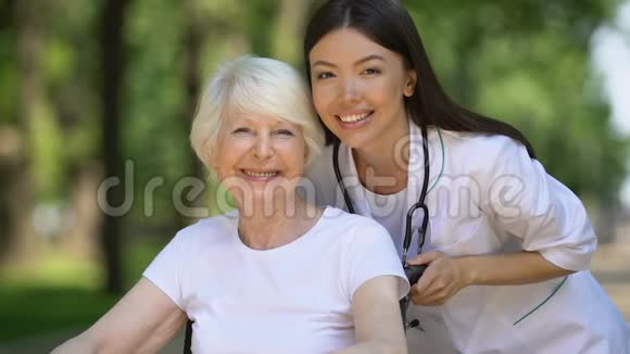 坐在轮椅上的开朗的女人和对着镜头微笑的医生视频的预览图